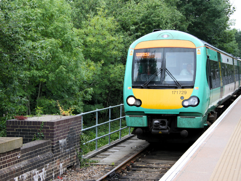 A Green and white train sitting at a platform, which 'Uckfield' written as its destination